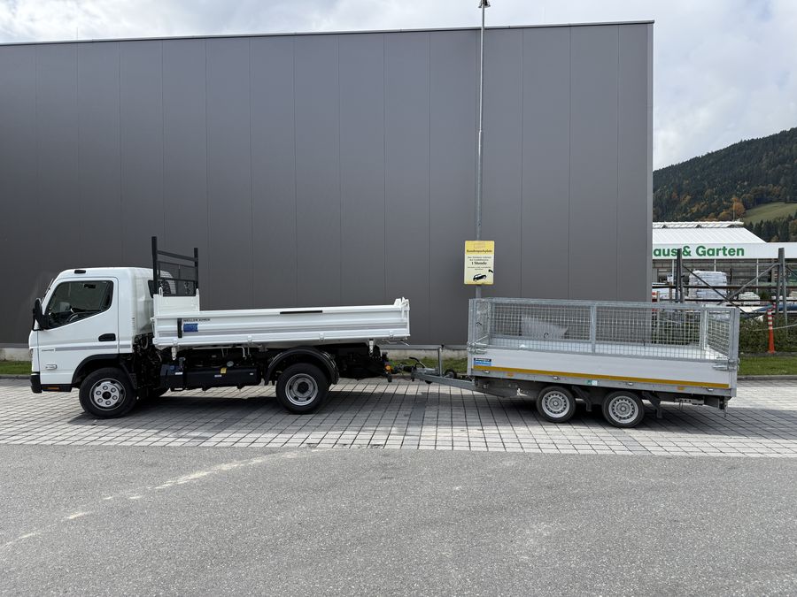 Weißer Klein-LKW mit Kipp-Pritsche, dahinter angehängt ein zweiachsiger
                 Kippanhänger mit Gitteraufsatz — beide leer, von der Seite fotografiert.